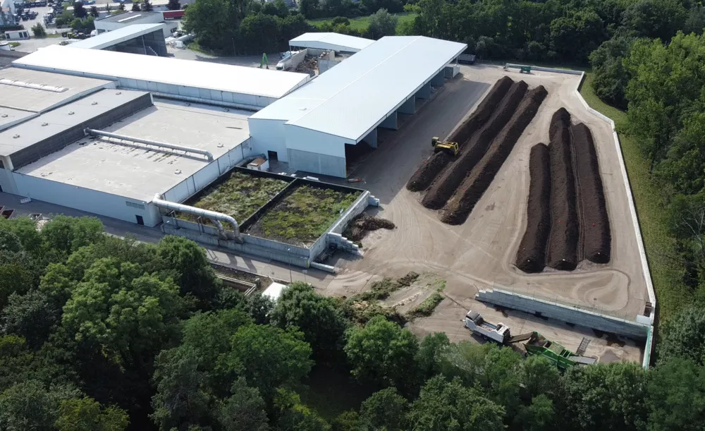 Kompost-Traktor auf Feld grüner Traktor mit Kompost-Anhänger auf gelbem Feld